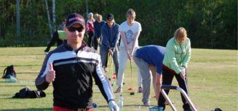 Etualalla tyytyväinen golfinpelaaja ja taustalla muita pelaamassa